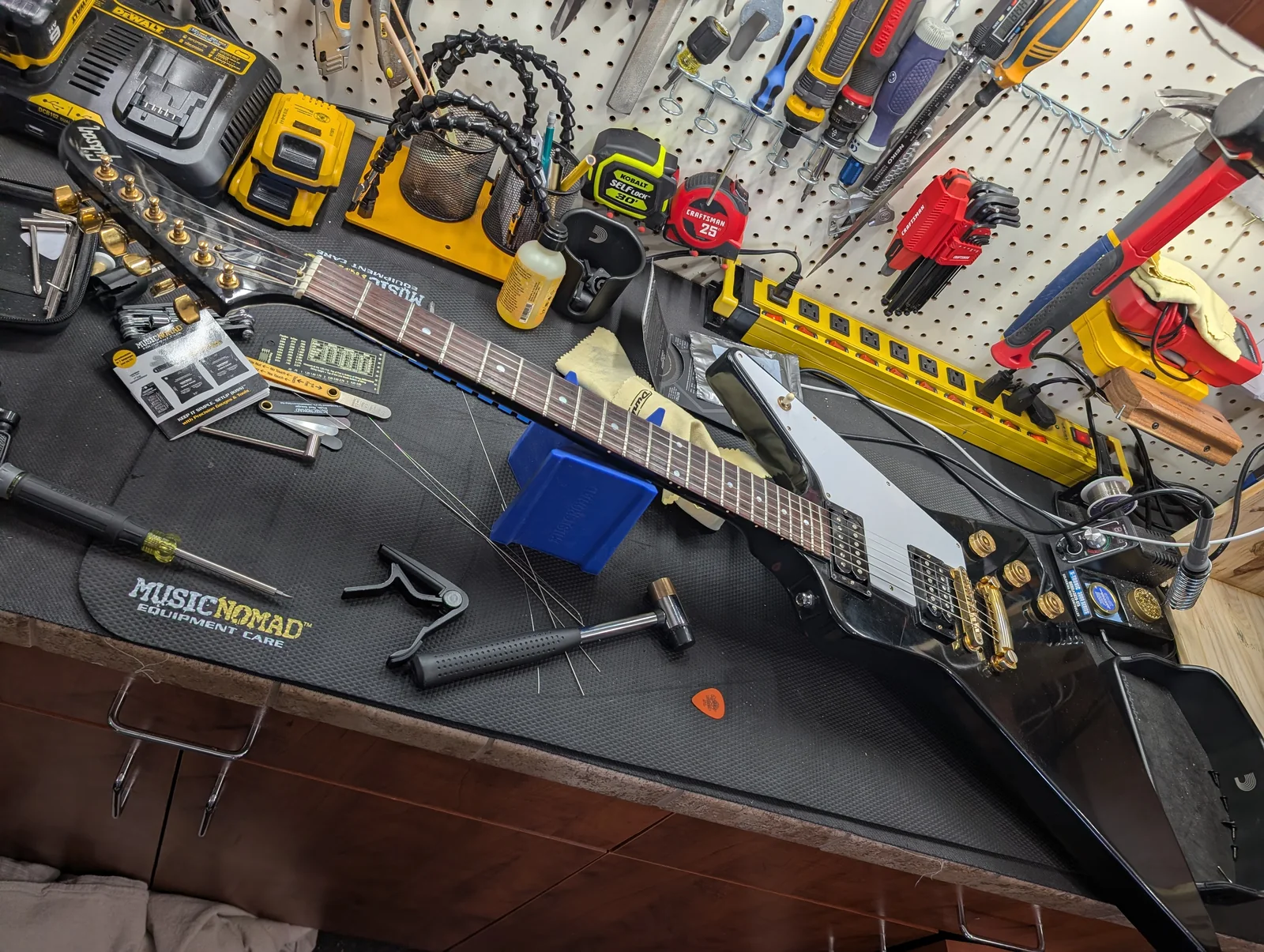 Electric guitar receiving a setup on the workbench